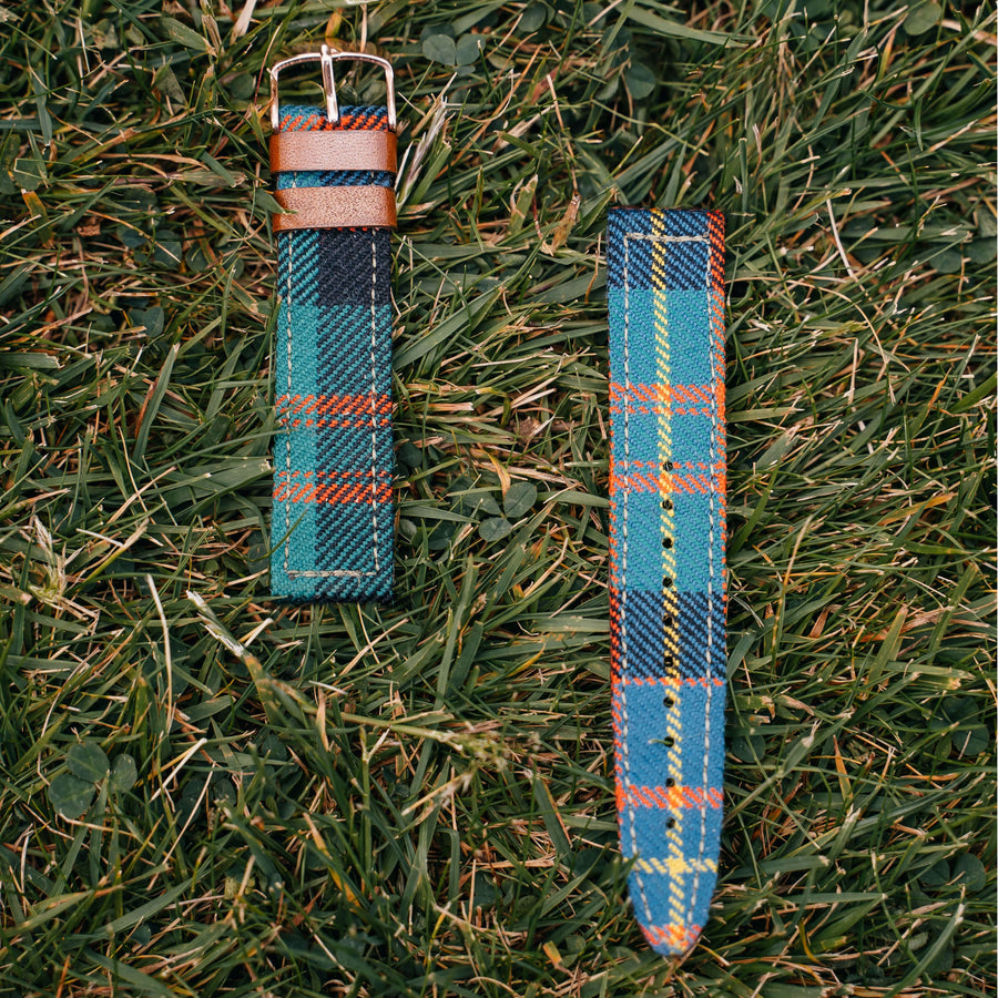 Close-up of a blue, green and orange tartan watch strap with leather details